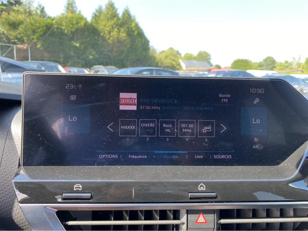 Écran tactile central du tableau de bord de la Citroën C4 2021, affichant la radio FM Skyrock en extérieur lumineux.