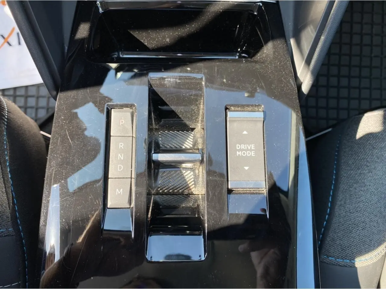 Gros plan sur la console centrale noire brillante de la Citroën C4 2021 avec commandes de boîte auto et mode de conduite.
