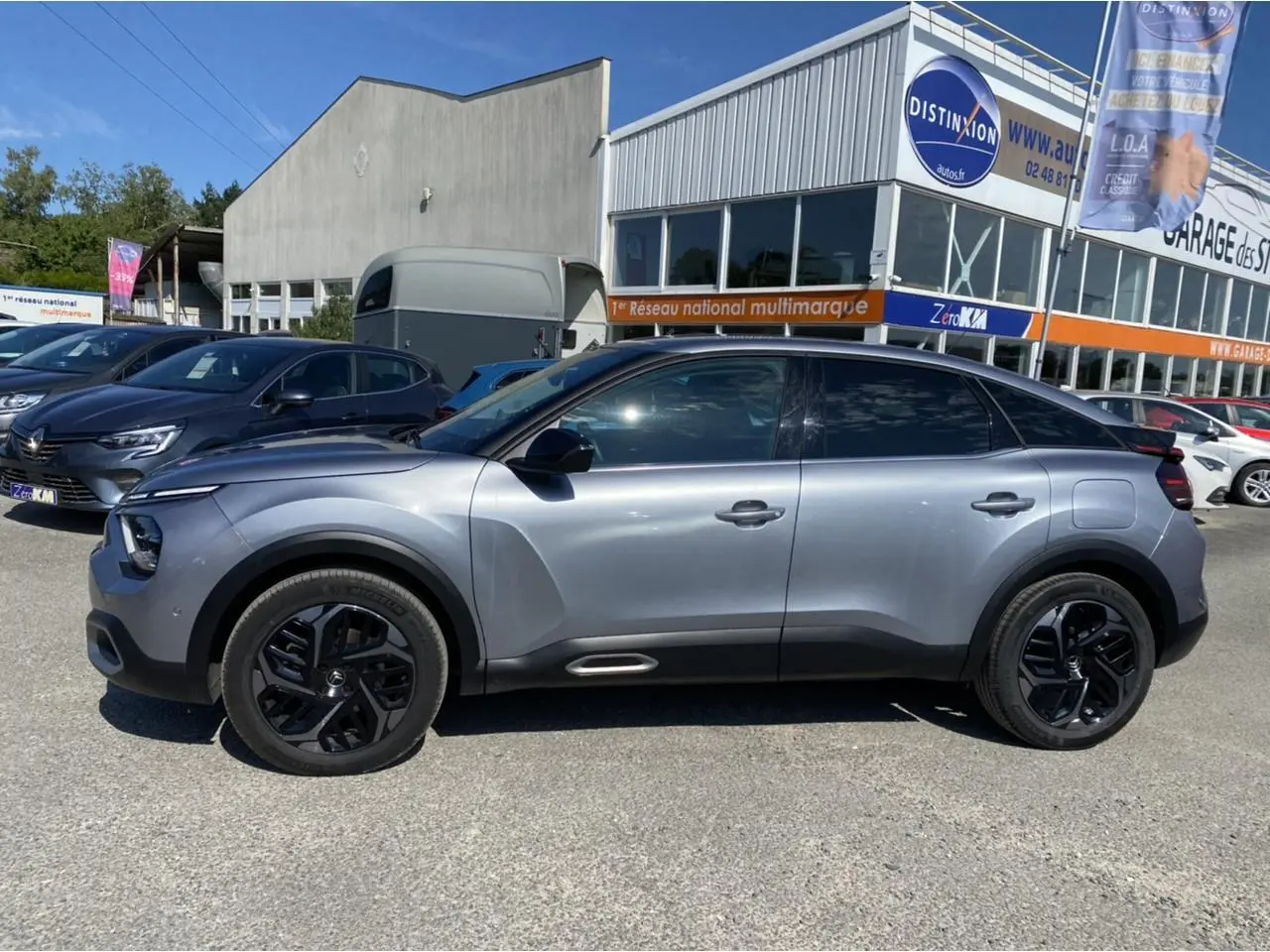 Vue de profil côté gauche d'une Citroën C4 gris foncé 2021 avec jantes noires et toit noir brillant.