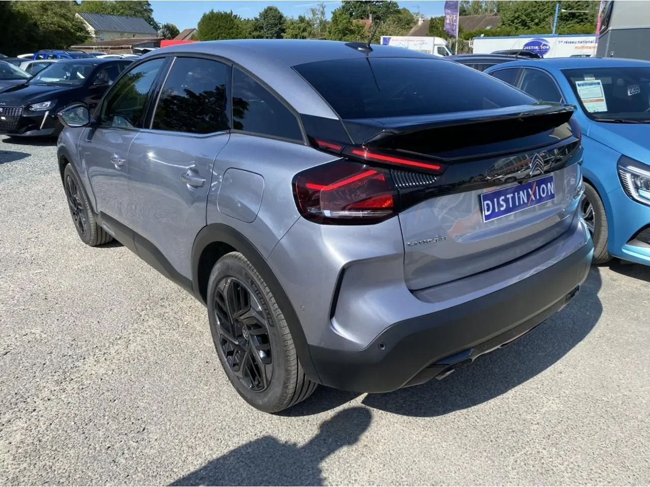 Vue 3/4 arrière droite d'une Citroën C4 gris foncé 2021 avec jantes noires et toit noir brillant.