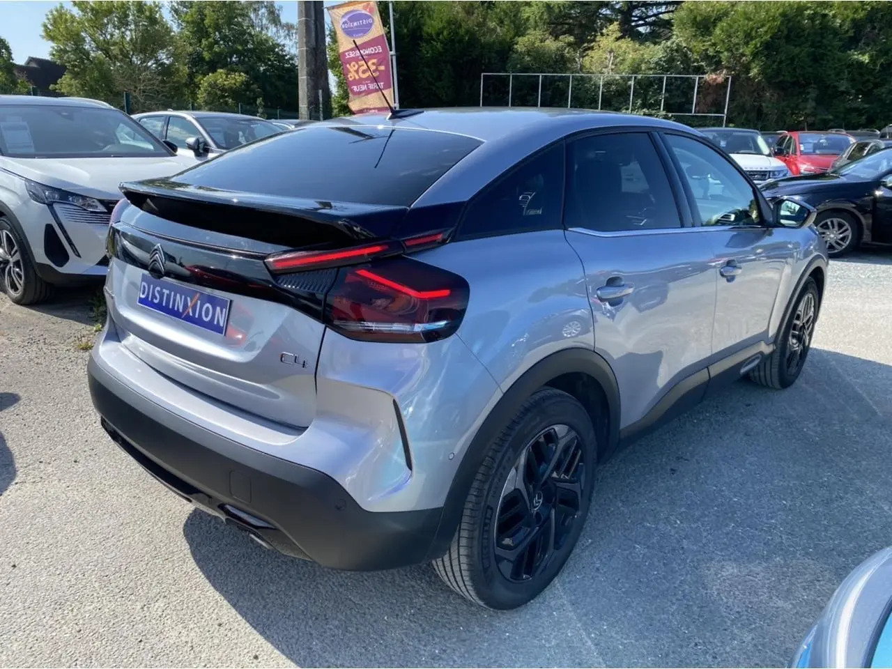 Vue 3/4 arrière droite d'une Citroën C4 gris foncé 2021 avec toit noir et jantes noires distinctives.