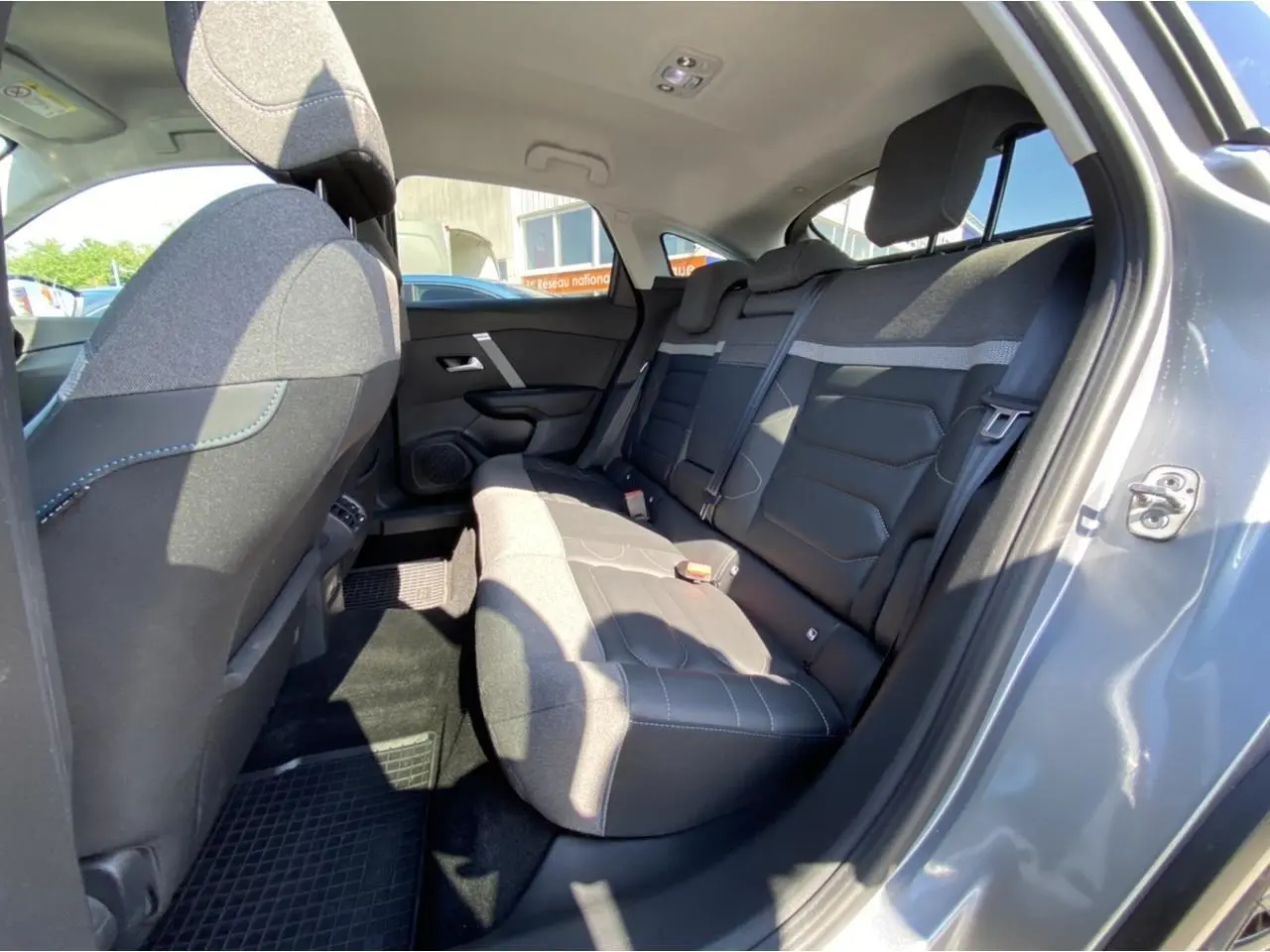 Vue intérieure arrière côté droit de la Citroën C4 2021 gris foncé, montrant les sièges arrière en tissu et cuir.