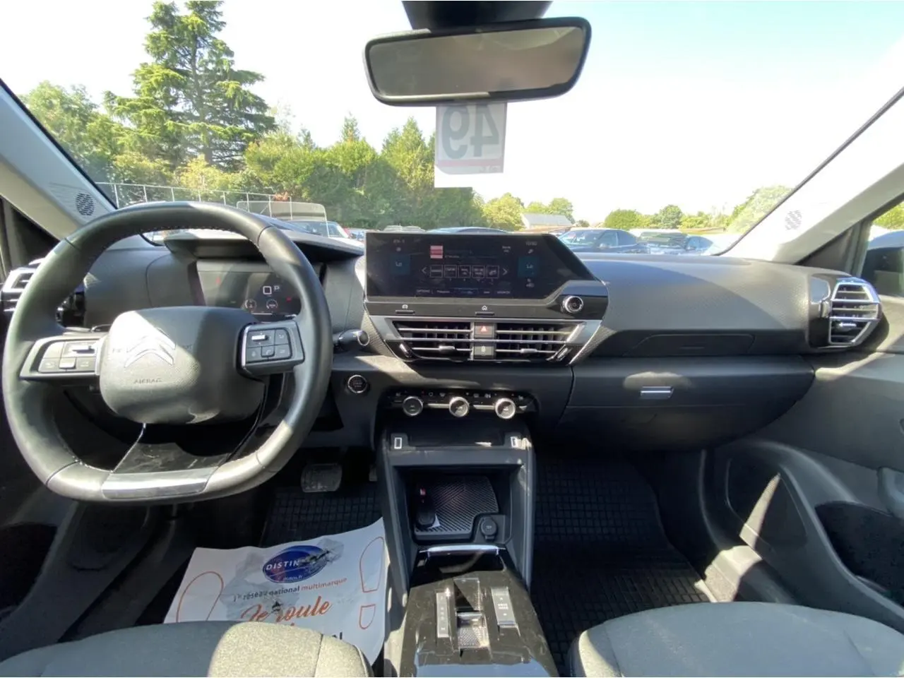 Vue intérieure avant de la Citroën C4 2021 gris foncé, montrant le tableau de bord moderne avec écran tactile central.