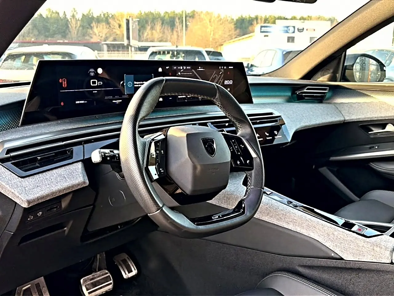 Intérieur du Peugeot 3008 gris, vue du poste de conduite avec volant cuir multifonction et écran numérique large.