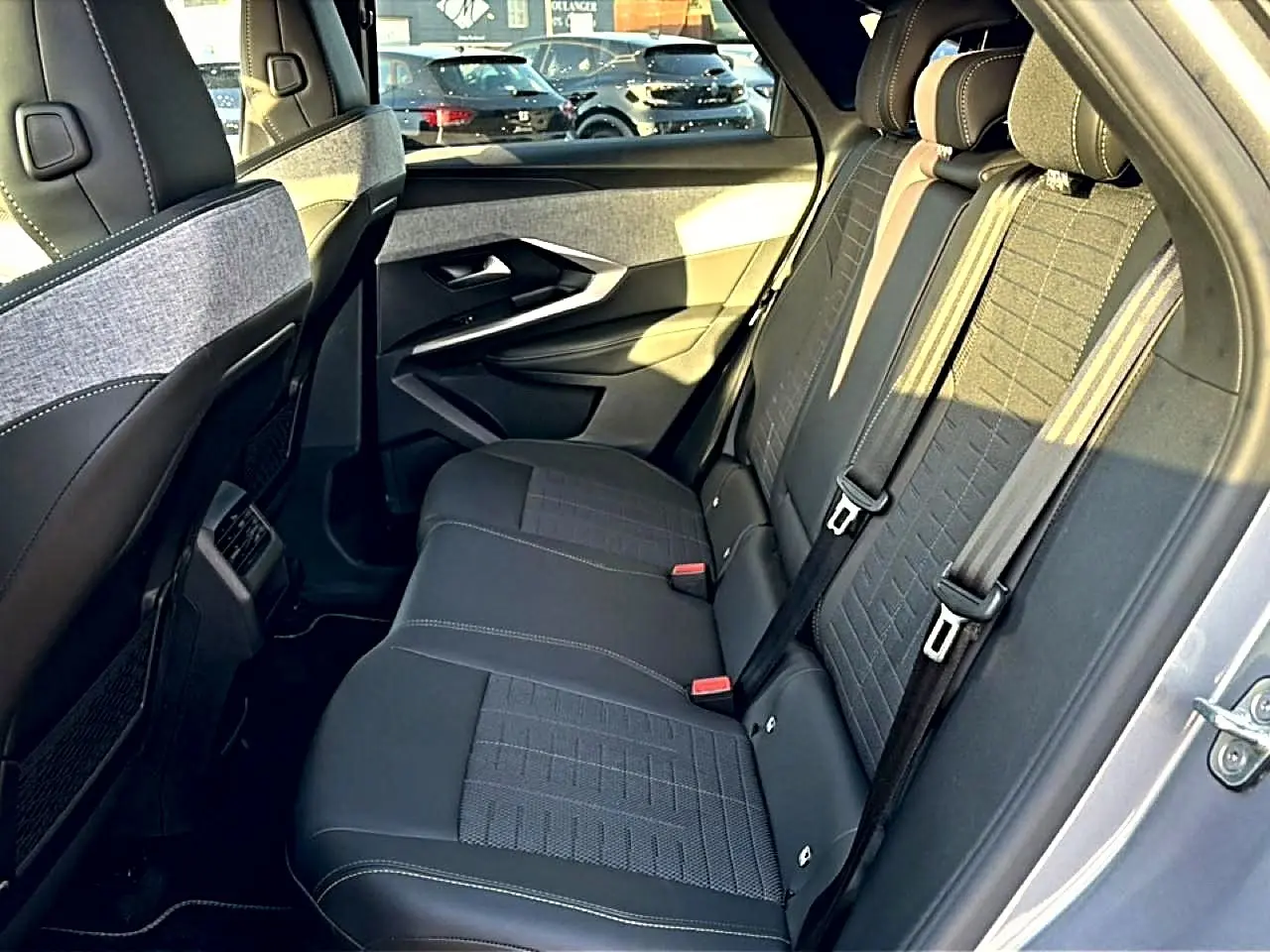 Vue côté droit de la banquette arrière grise du Peugeot 3008 1.2 hybrid 145 GT, avec ceintures de sécurité visibles.