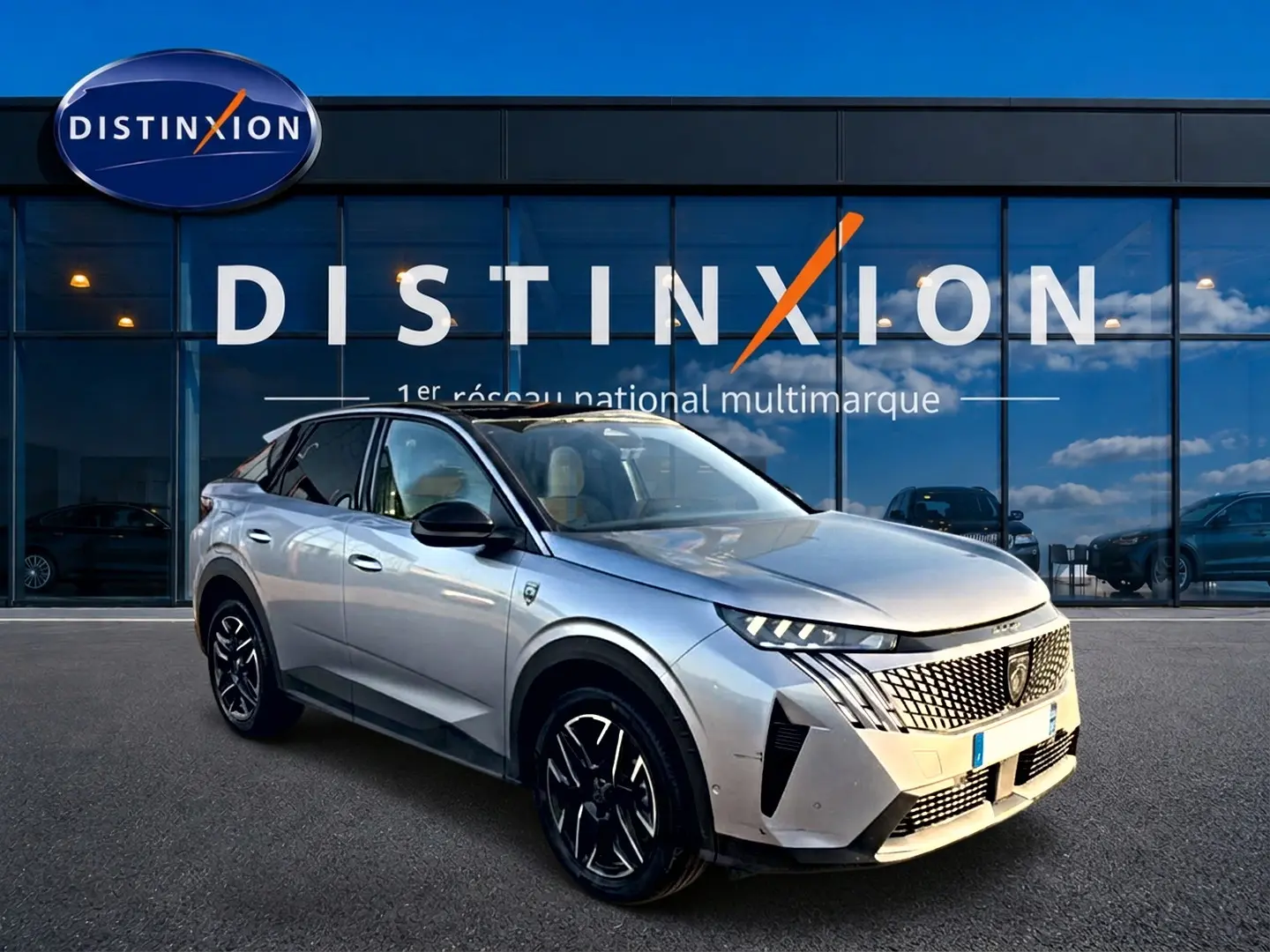 Peugeot 3008 gris en 3/4 avant droit, avec calandre distinctive et jantes alliage noires devant showroom Distinxion.
