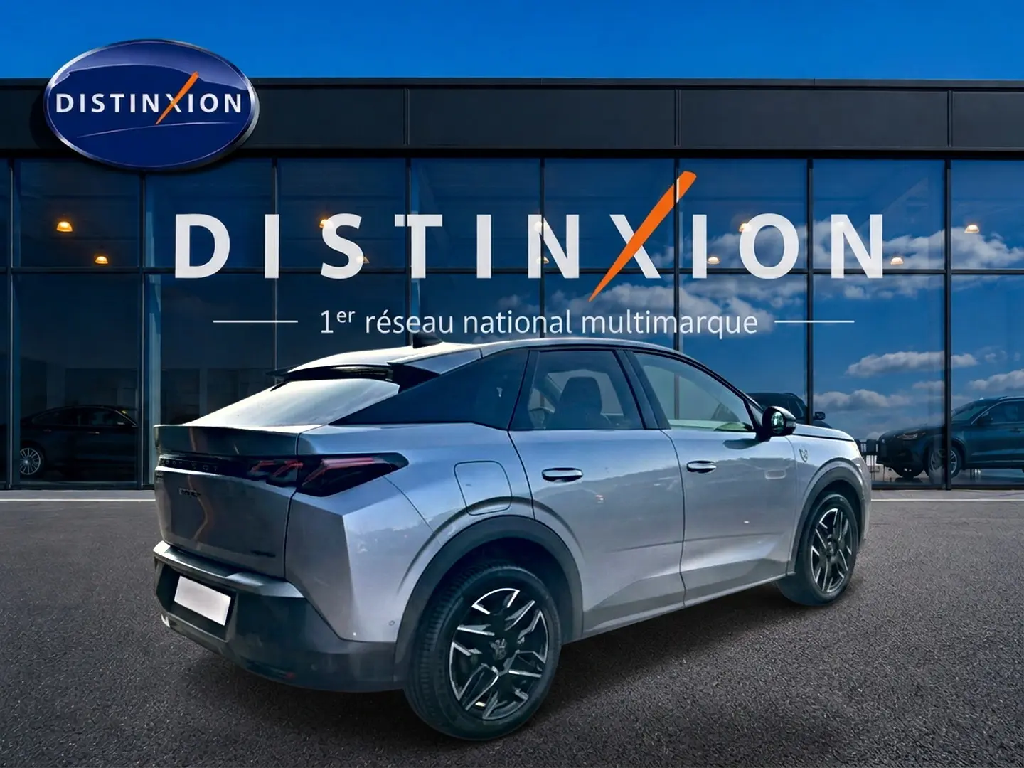 Peugeot 3008 gris en 3/4 arrière droit, avec jantes alu noires et toit noir contrasté, devant showroom Distinxion.