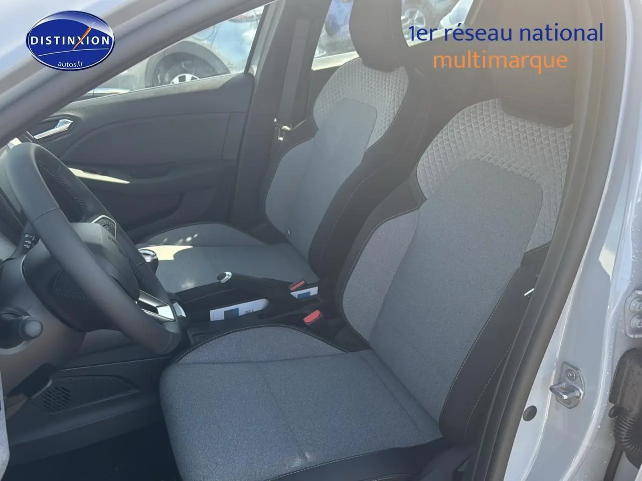 Intérieur de la Renault Clio V gris rafale, vue côté conducteur montrant les sièges avant et le volant multifonction.