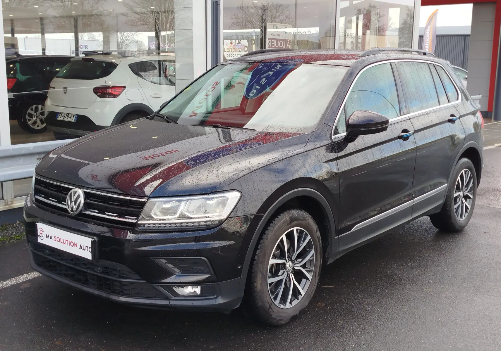 Volkswagen Tiguan noir nacré 2019 en 3/4 avant droit, avec jantes alliage et feux LED allumés.