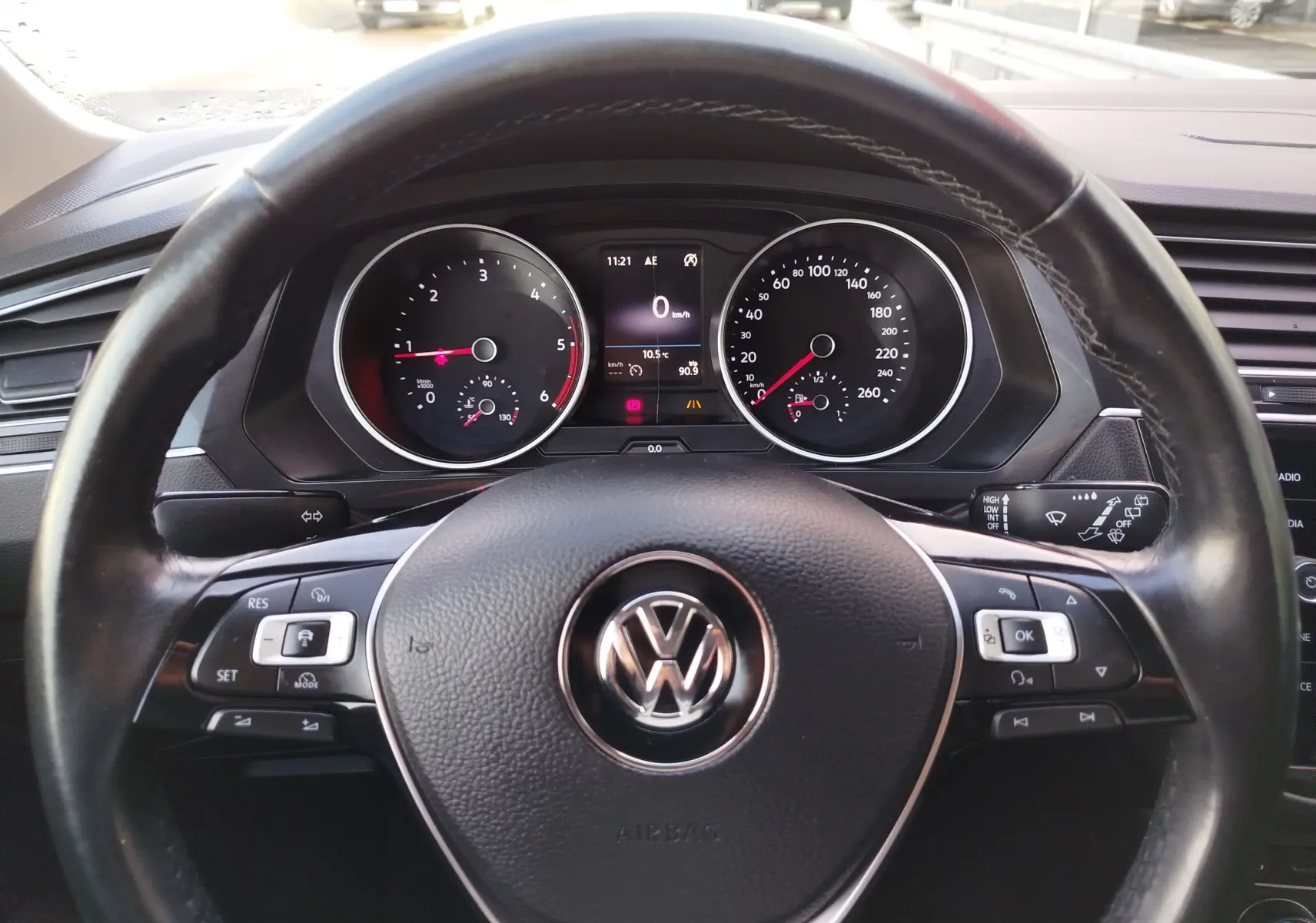 Vue rapprochée du volant noir de Volkswagen Tiguan 2019 avec tableau de bord et compteurs analogiques visibles.