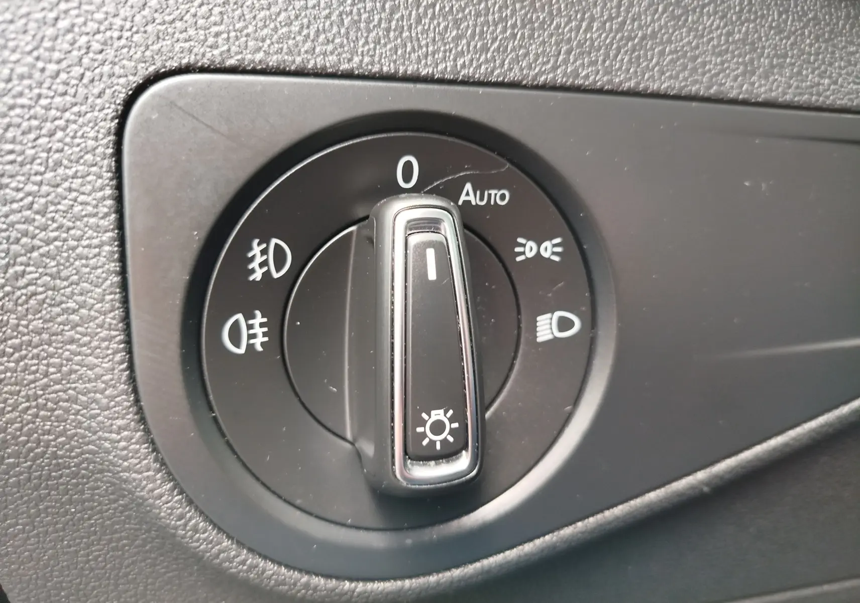 Gros plan sur le sélecteur de phares noir dans l’habitacle du Volkswagen Tiguan 2.0 TDI 2019.