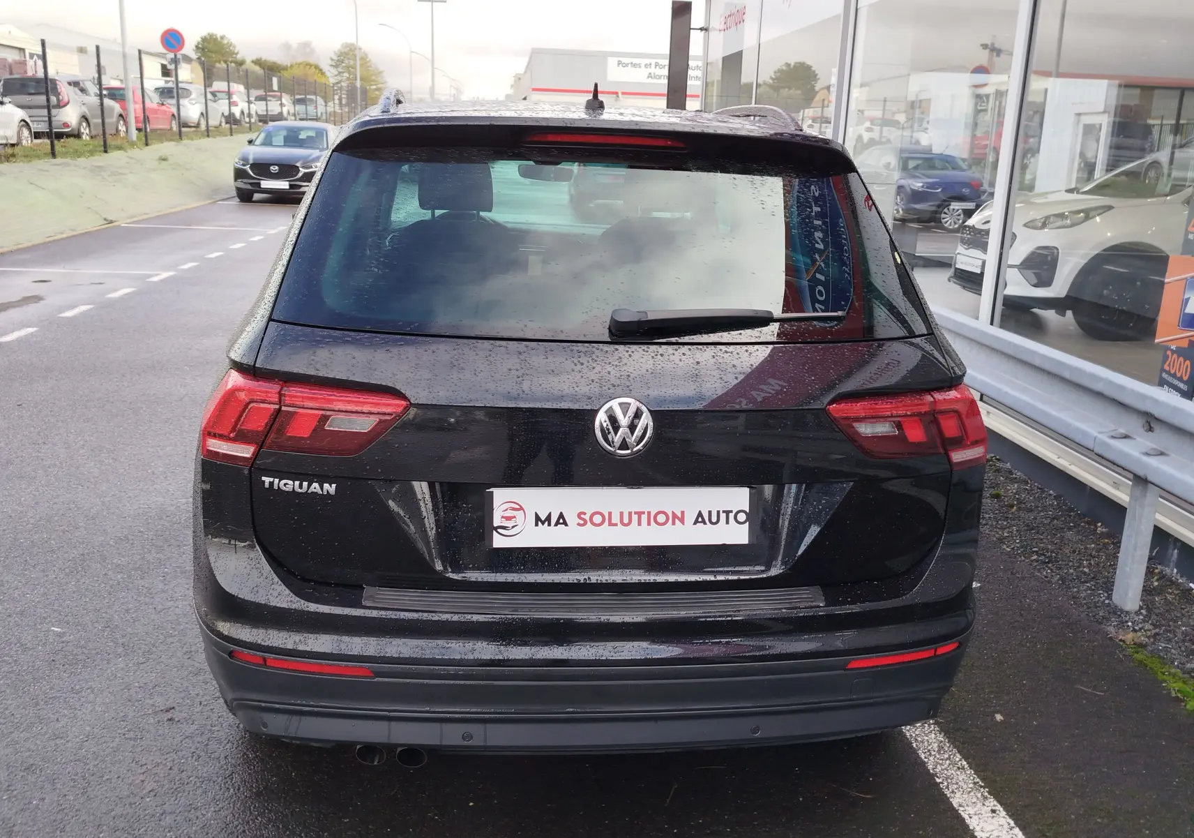 Vue arrière d'un Volkswagen Tiguan noir intense nacré de 2019, avec feux arrière LED et logo VW bien visibles.