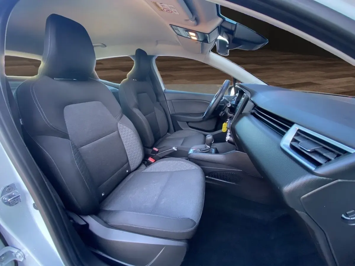 Vue intérieure côté conducteur de la Renault Clio Business E-TECH 140 2021, sièges tissu noir et tableau de bord moderne.