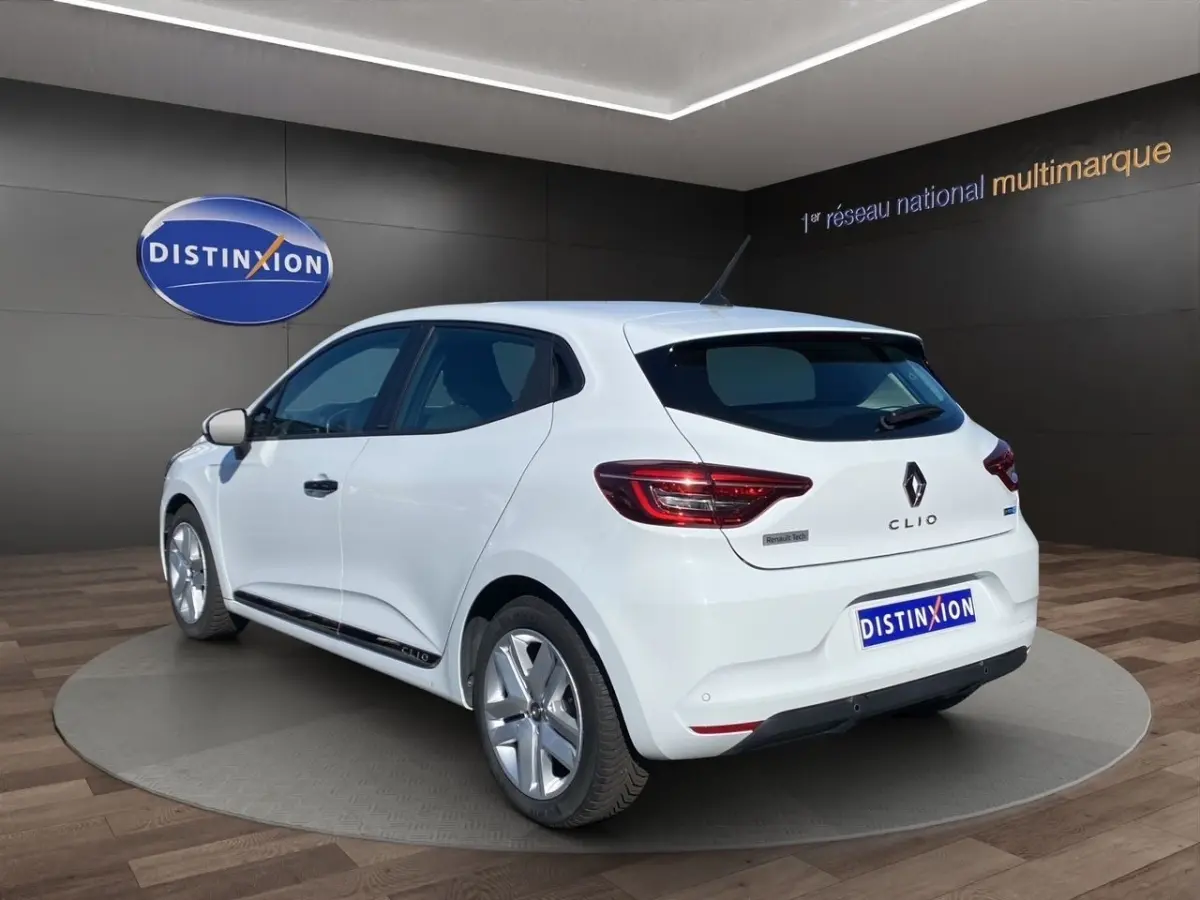 Vue 3/4 arrière droite d'une Renault Clio blanche 2021 avec feux LED et logo Renault Tech visible.