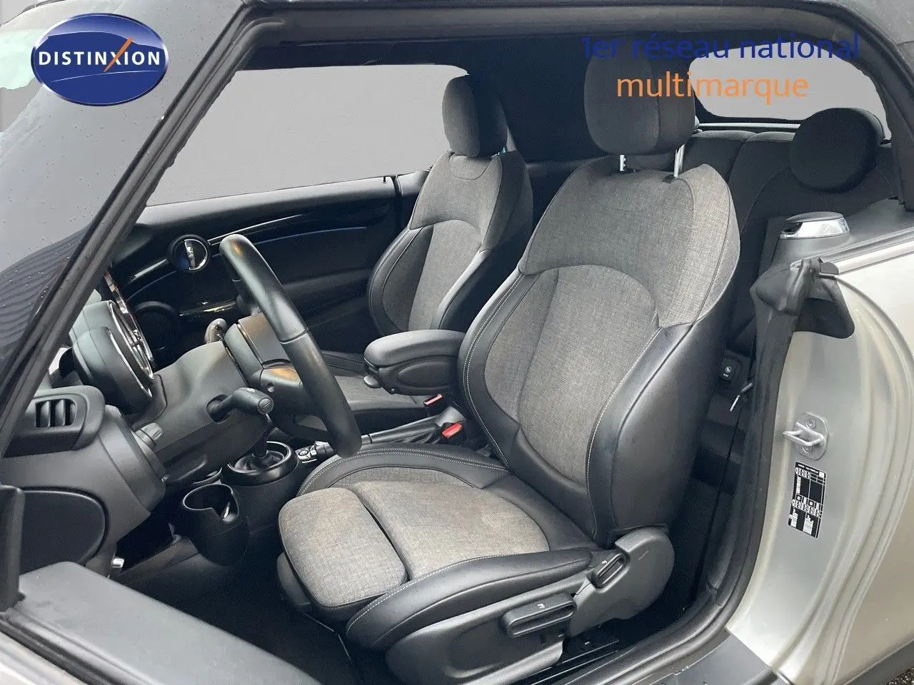 Vue intérieure côté conducteur d'une MINI Cabriolet Melting Silver avec sièges tissu gris et cuir noir.