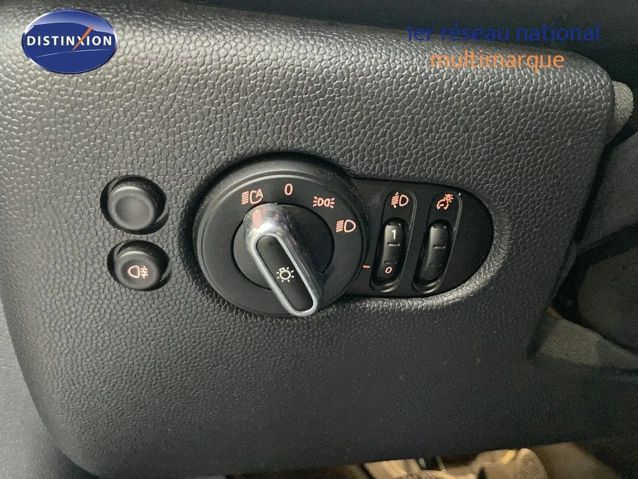 Gros plan sur les commandes d'éclairage intérieures en plastique noir du MINI Cabriolet Melting Silver 2023.