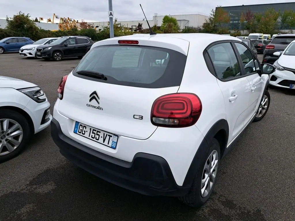 Vue 3/4 arrière droite d'une Citroën C3 Société blanche avec feux arrière distinctifs et pare-chocs noirs.