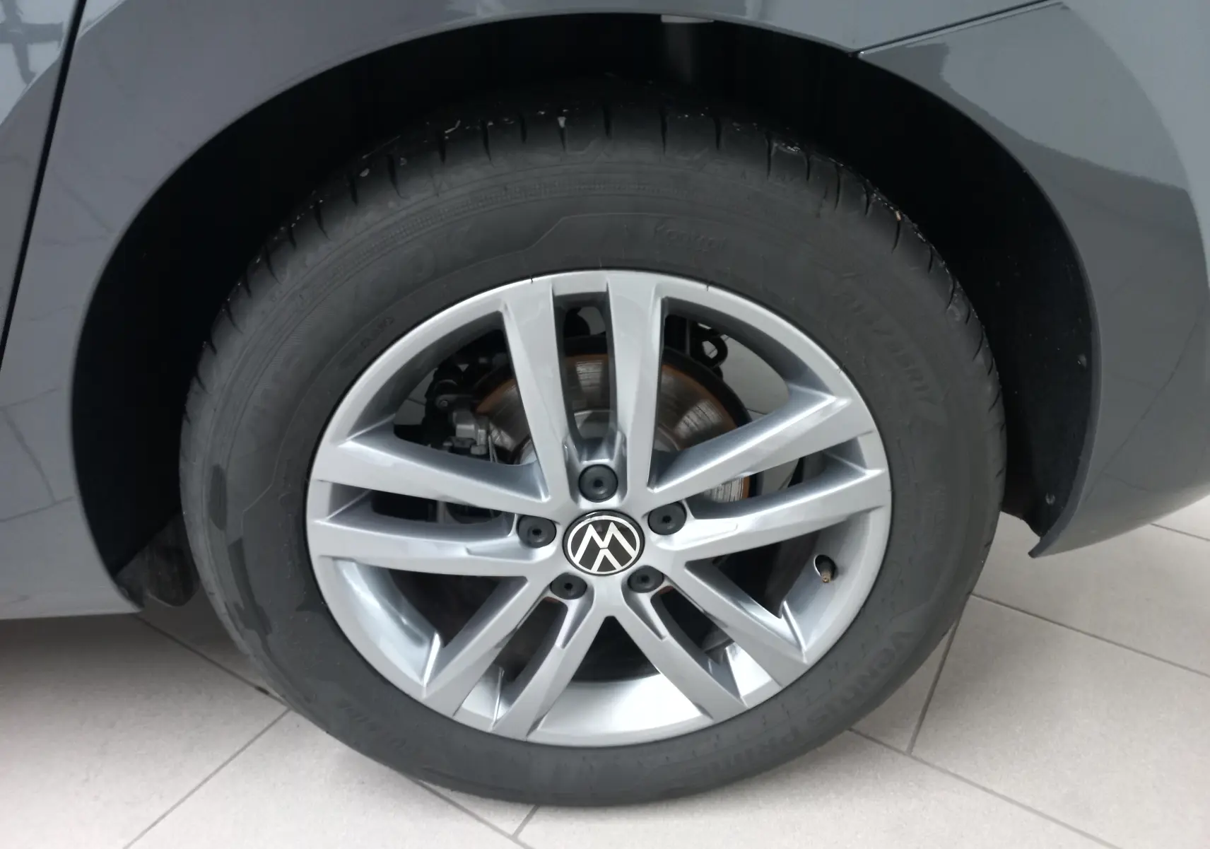 Gros plan sur la roue avant droite gris dauphin du Volkswagen Touran 2025 avec jante alliage à 10 branches.