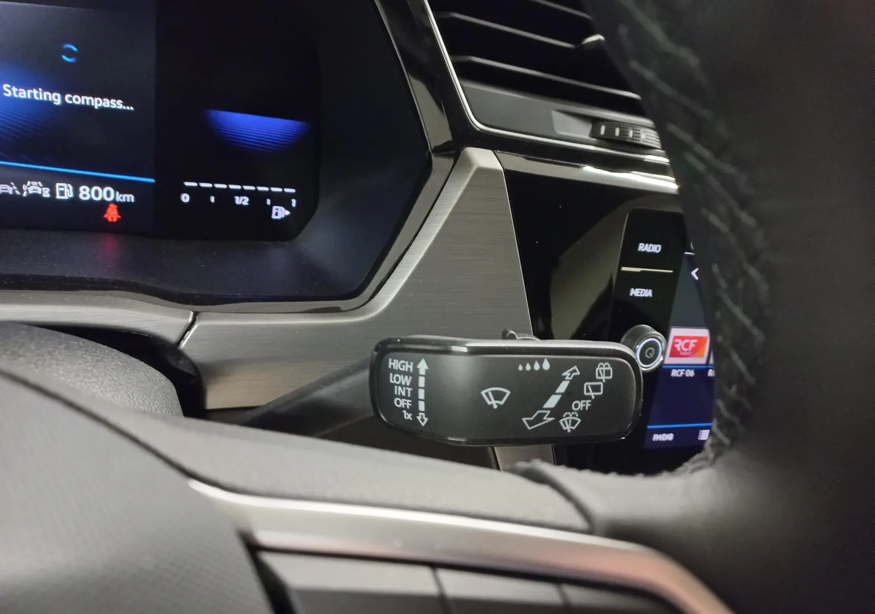 Gros plan sur la commande des essuie-glaces côté droit du tableau de bord du Volkswagen Touran 2025 Gris Dauphin.