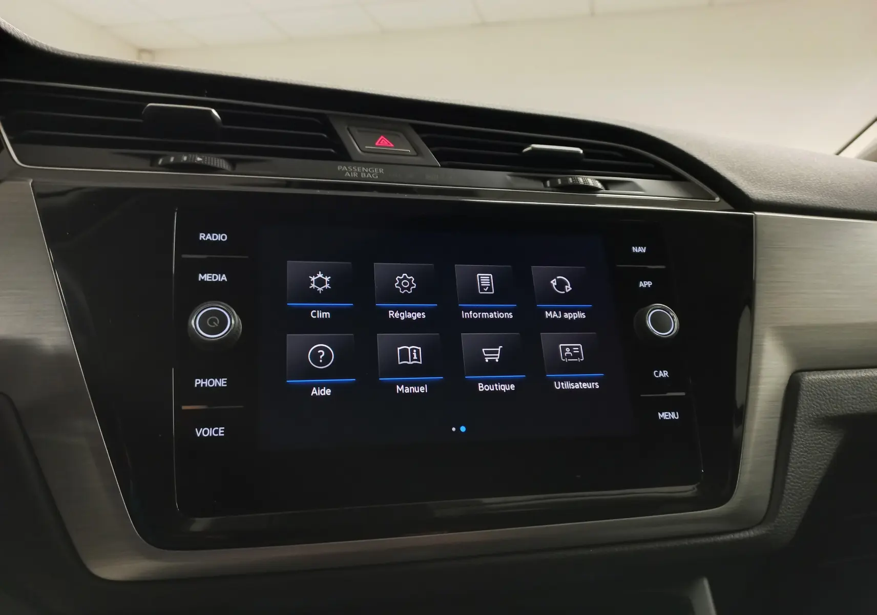 Écran tactile central du Volkswagen Touran 2025 affichant le menu principal avec commandes clim et réglages.