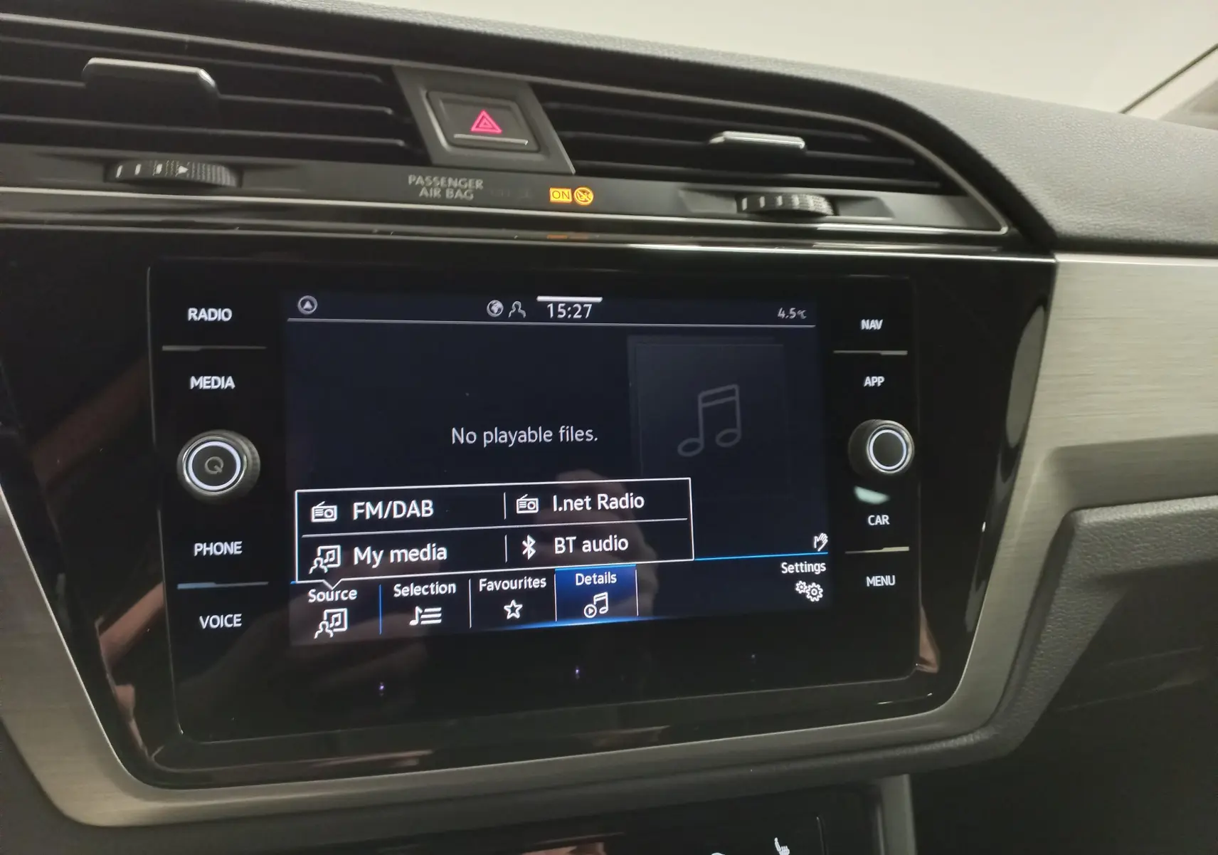 Gros plan sur l’écran tactile multimédia du Volkswagen Touran 2025, tableau de bord noir avec finitions gris métallisé.