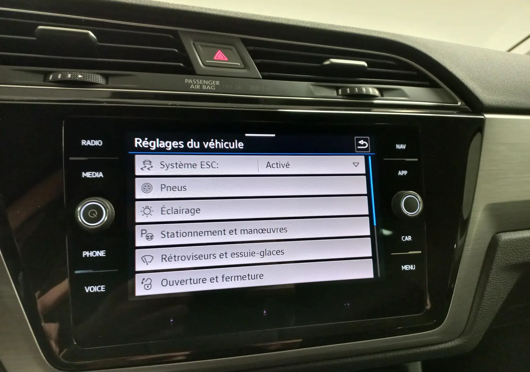 Écran tactile central du Volkswagen Touran 2025 affichant les réglages du véhicule, avec finition intérieure noire et grise.