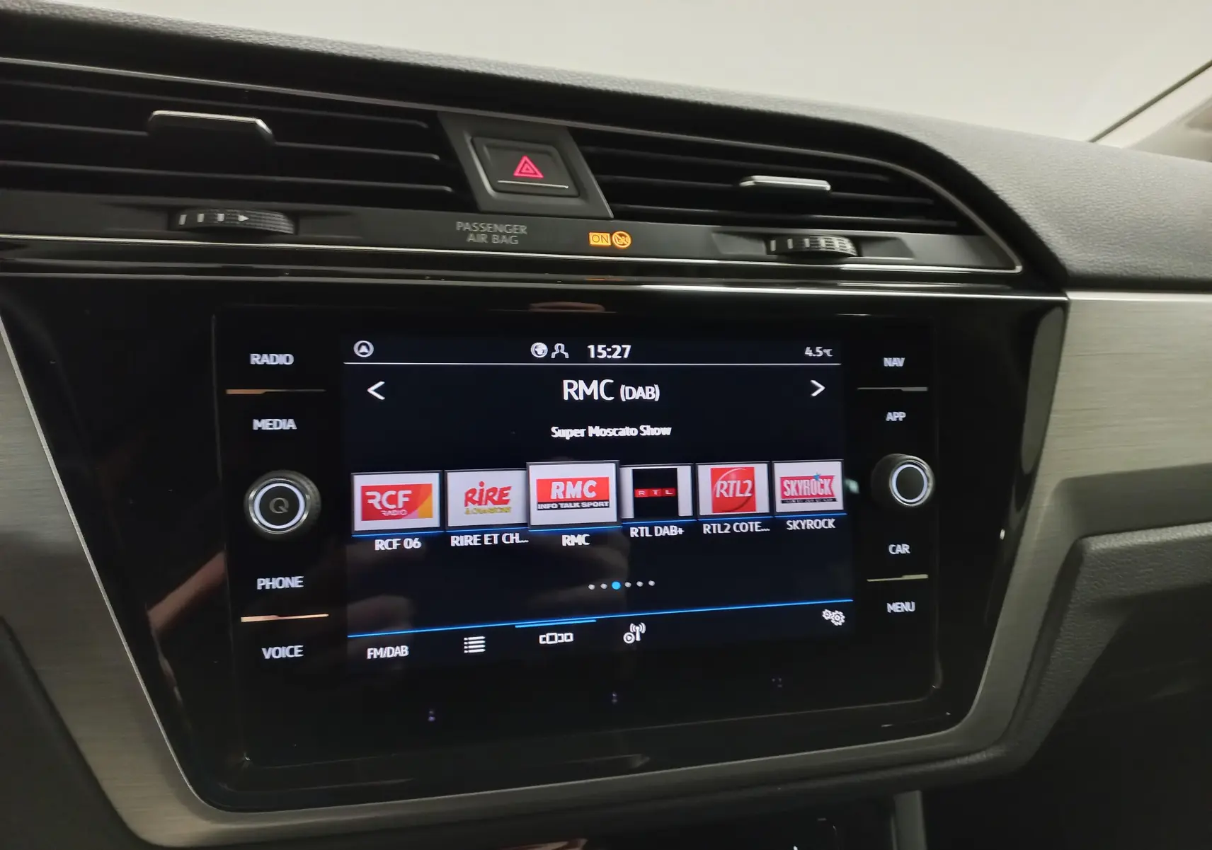 Vue rapprochée de l’écran multimédia tactile du Volkswagen Touran 2025 avec interface radio digitale affichée.