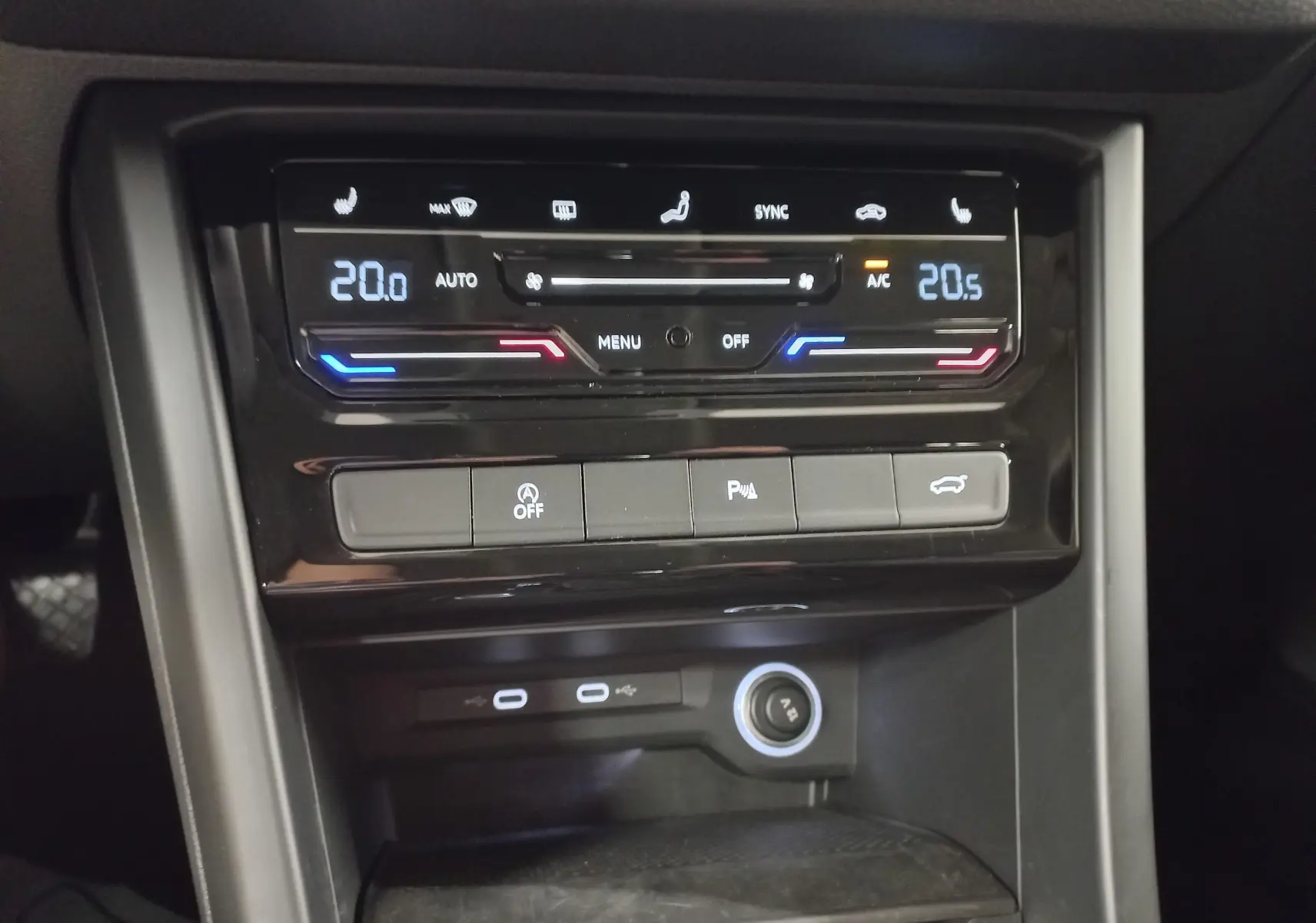 Détail de la console centrale du Volkswagen Touran 2025, affichage numérique de la climatisation et boutons de commande.
