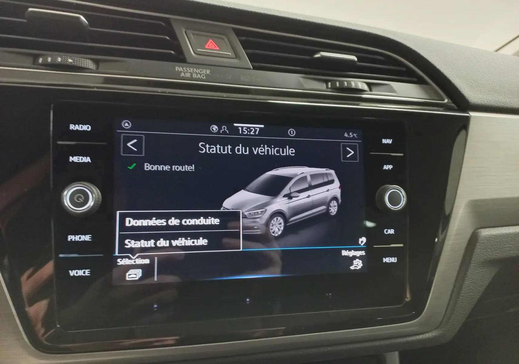 Écran central affichant le statut du Volkswagen Touran gris dauphin, vue 3/4 avant sur l'interface multimédia.