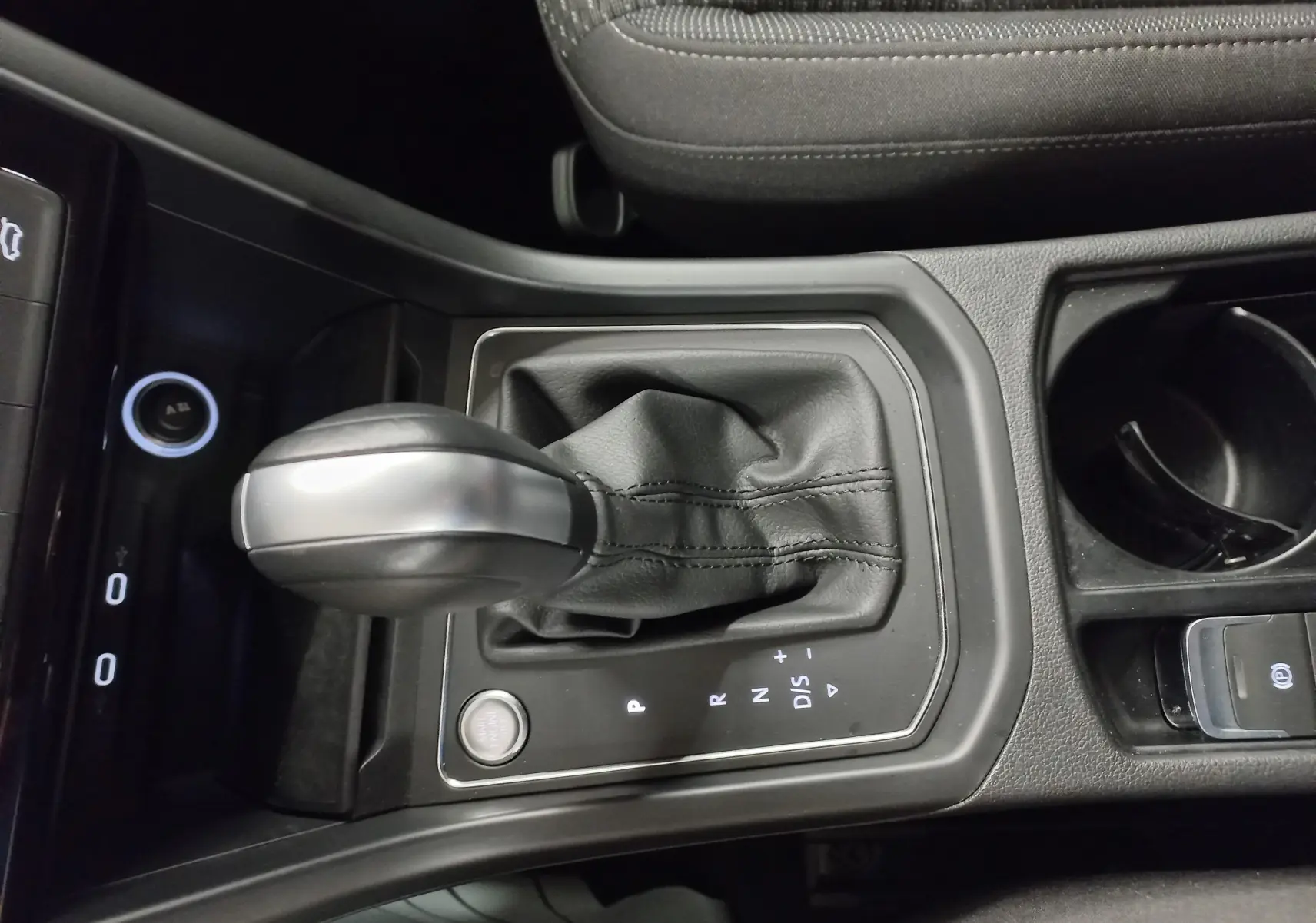 Vue rapprochée de la console centrale du Volkswagen Touran 2025, avec levier de vitesse automatique et bouton start/stop.