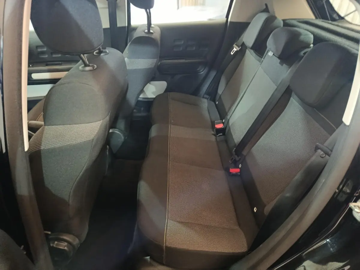 Vue intérieure côté droit montrant la banquette arrière noire de la Citroën C3 BlueHDi 100 BVM PLUS 2024.