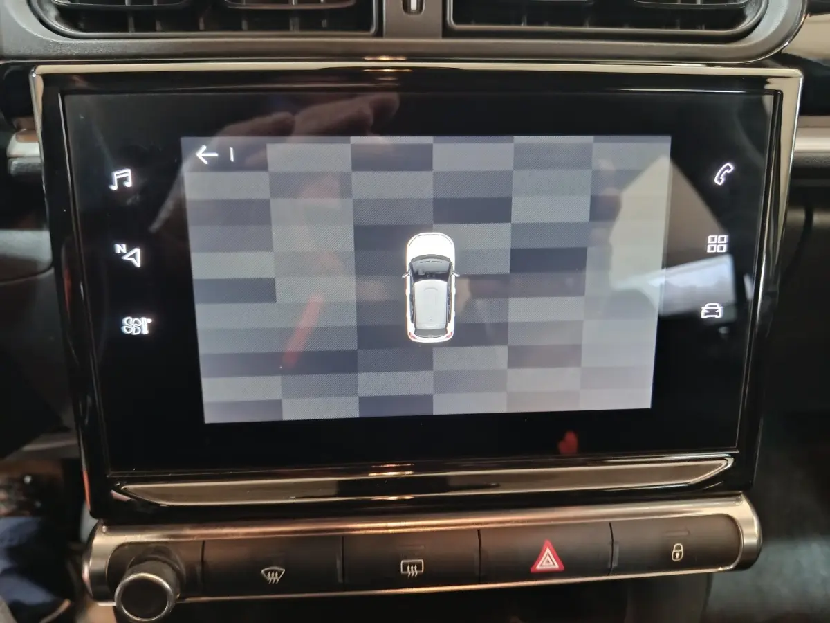 Écran tactile central affichant la vue aérienne du véhicule Citroën C3 noir, tableau de bord intérieur visible.