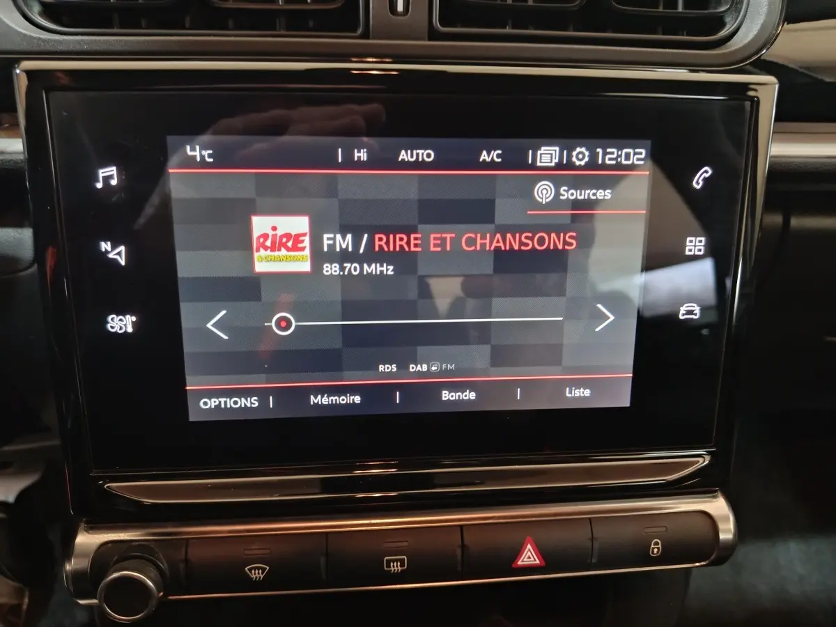 Écran tactile central de la Citroën C3 2024 noir affichant la radio FM sur fond sombre avec commandes tactiles.