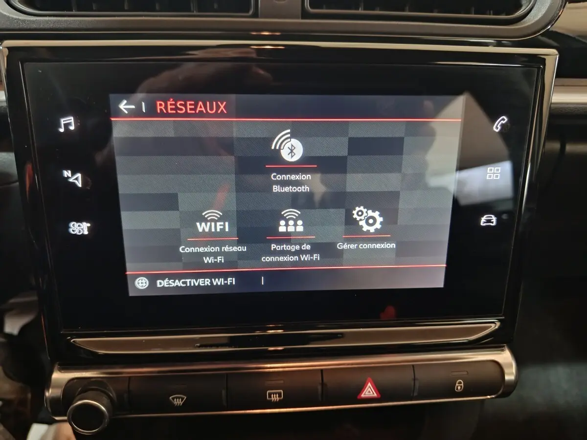 Écran tactile central de la Citroën C3 2024 affichant les options de connexion Bluetooth et Wi-Fi, intérieur noir.