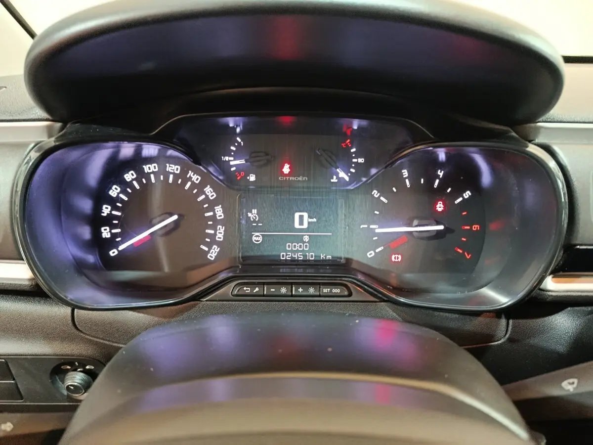 Vue rapprochée du tableau de bord noir de la Citroën C3 2024, affichant la vitesse à 0 km/h et les voyants allumés.