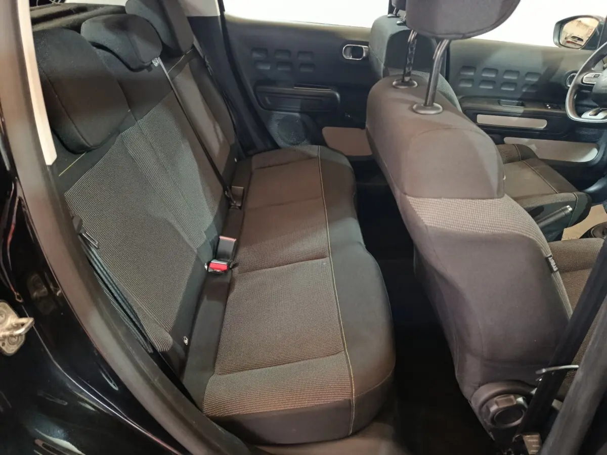 Vue intérieure côté gauche montrant la banquette arrière noire et les sièges avant du Citroën C3 2024.