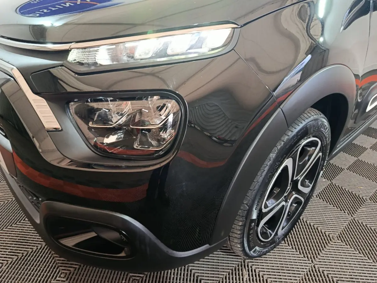 Gros plan sur l'avant droit noir brillant d'une Citroën C3 2024 avec phares LED et jante alliage distinctive.