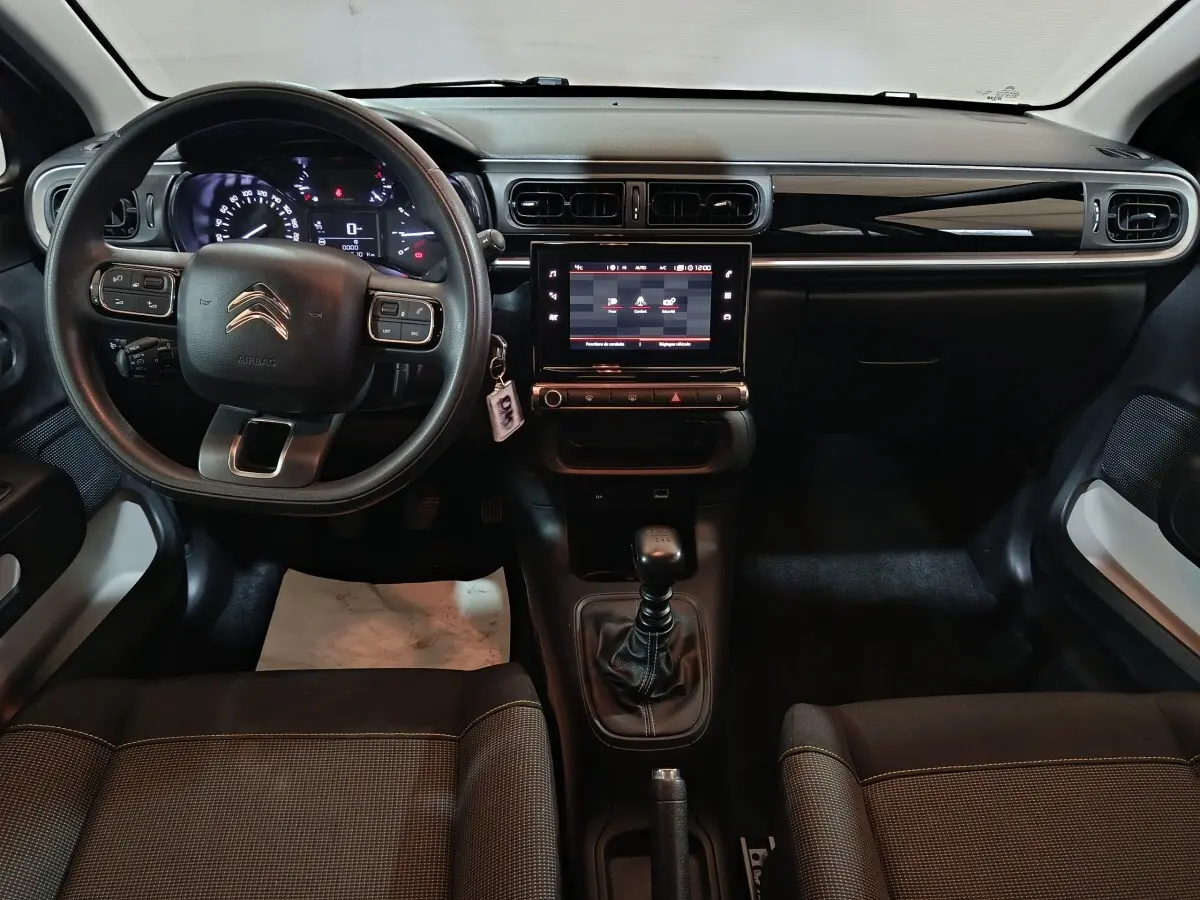 Vue intérieure avant de la Citroën C3 2024 noire, avec tableau de bord central tactile et volant multifonctions réglable.