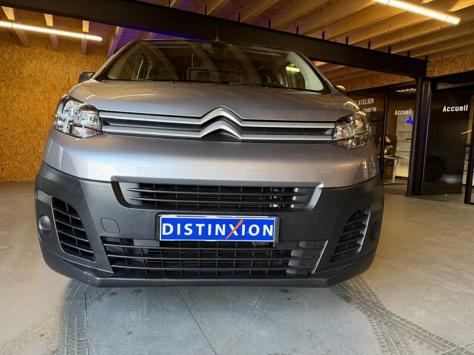Vue frontale du Citroën Jumpy gris métallisé 2022 avec calandre noire et plaque d'immatriculation Distinxion.