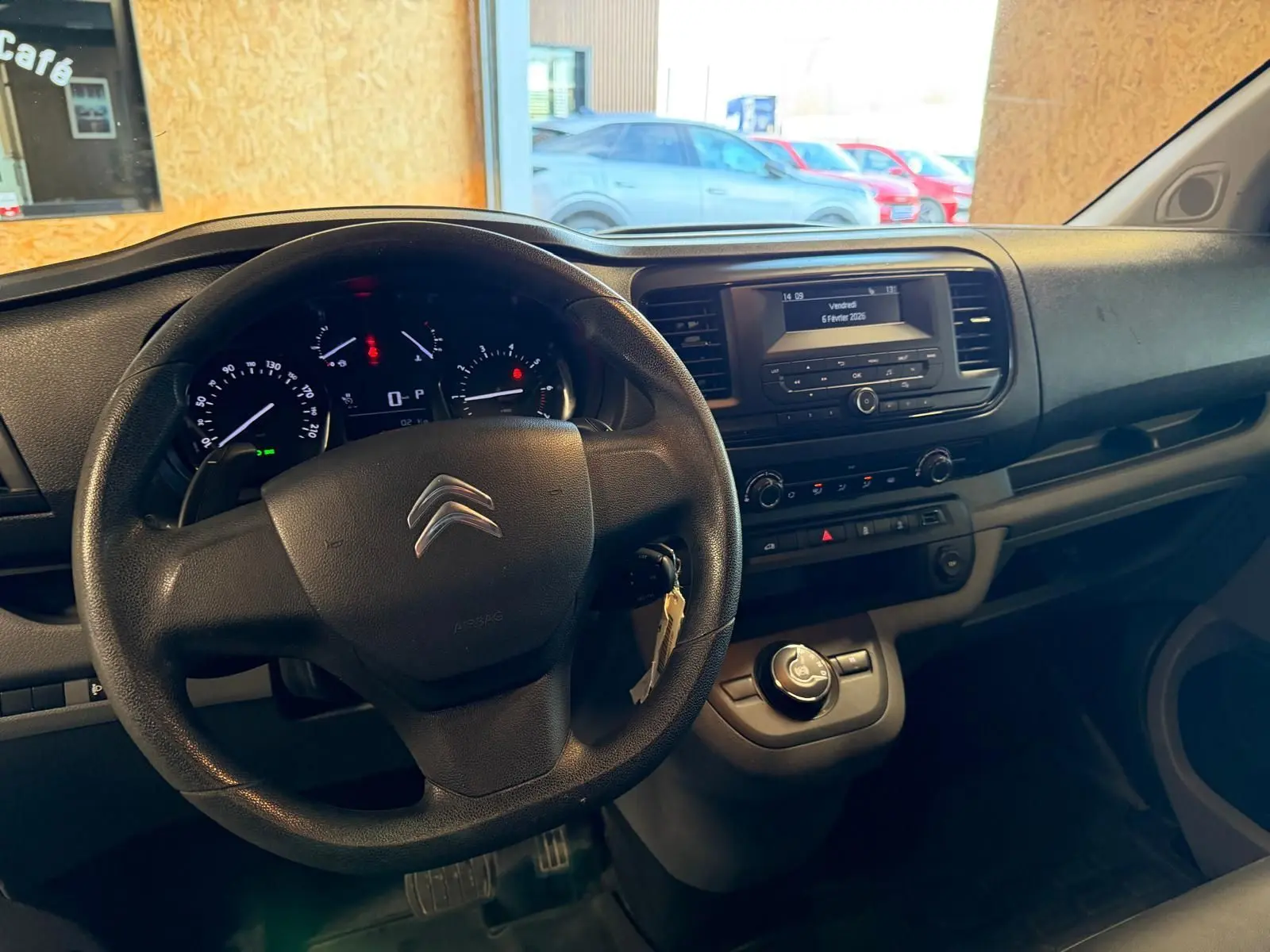 Vue intérieure du poste de conduite du Citroën Jumpy gris 2022, avec volant, tableau de bord et console centrale visibles.