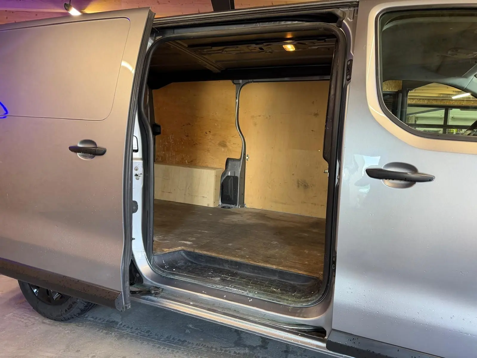 Vue latérale gauche d'un Citroën Jumpy gris 2022 avec porte latérale coulissante ouverte montrant l'espace de chargement.