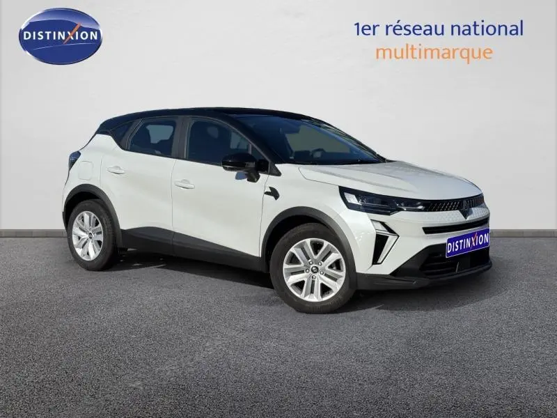 Renault Captur blanc nacré en 3/4 avant droit, toit noir contrasté et jantes alliage, version 2025 Essence manuelle.