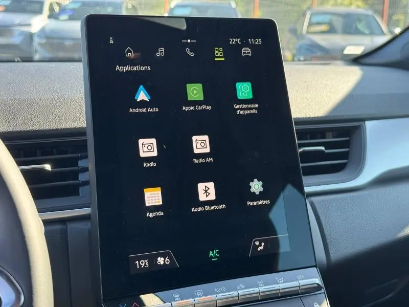 Écran tactile central du Renault Captur 2025 blanc nacré, affichant les applications Android Auto et Apple CarPlay.