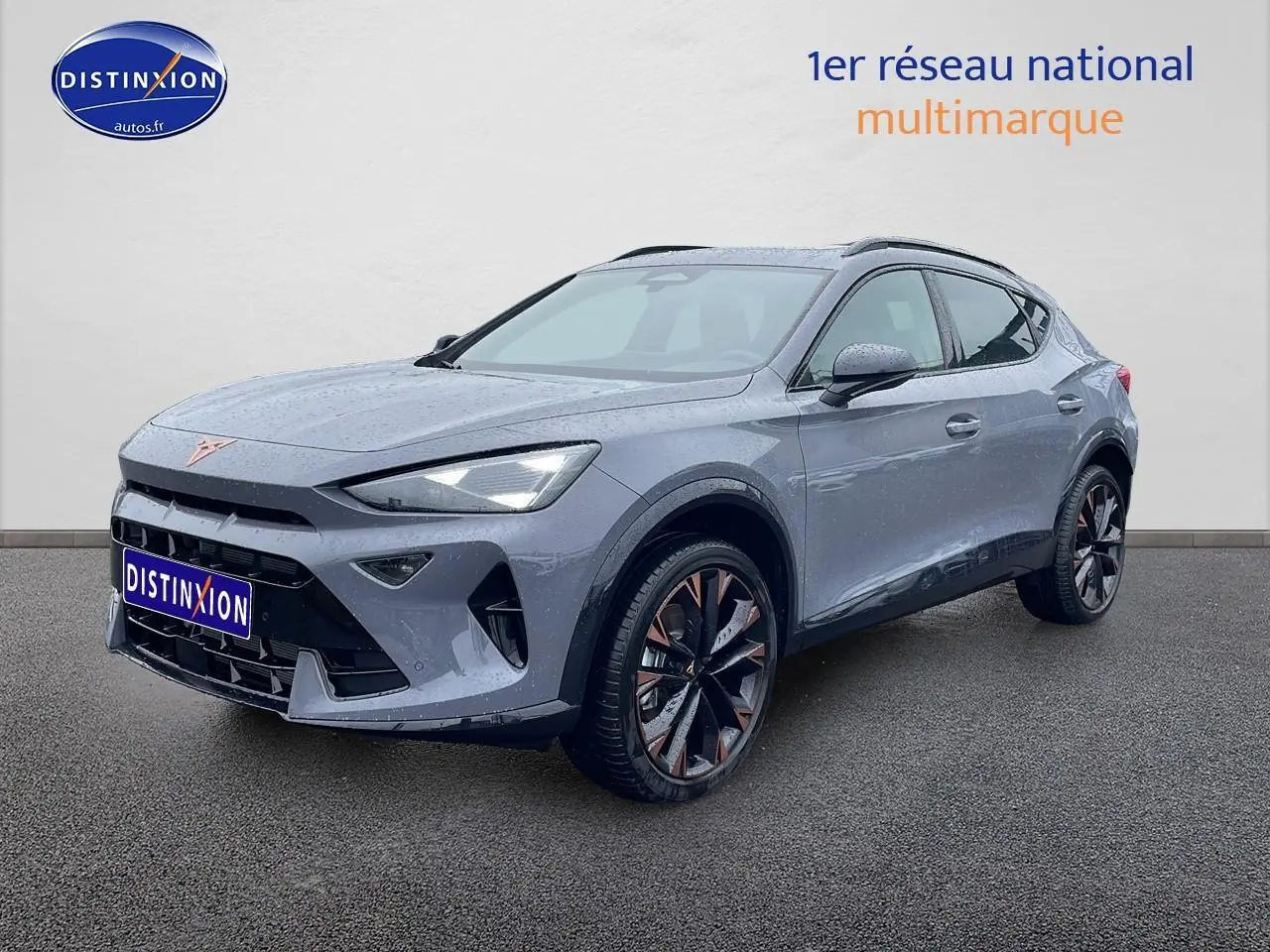 Vue 3/4 avant droite d'un CUPRA Formentor gris graphene avec jantes noires et cuivrées, sur fond neutre.