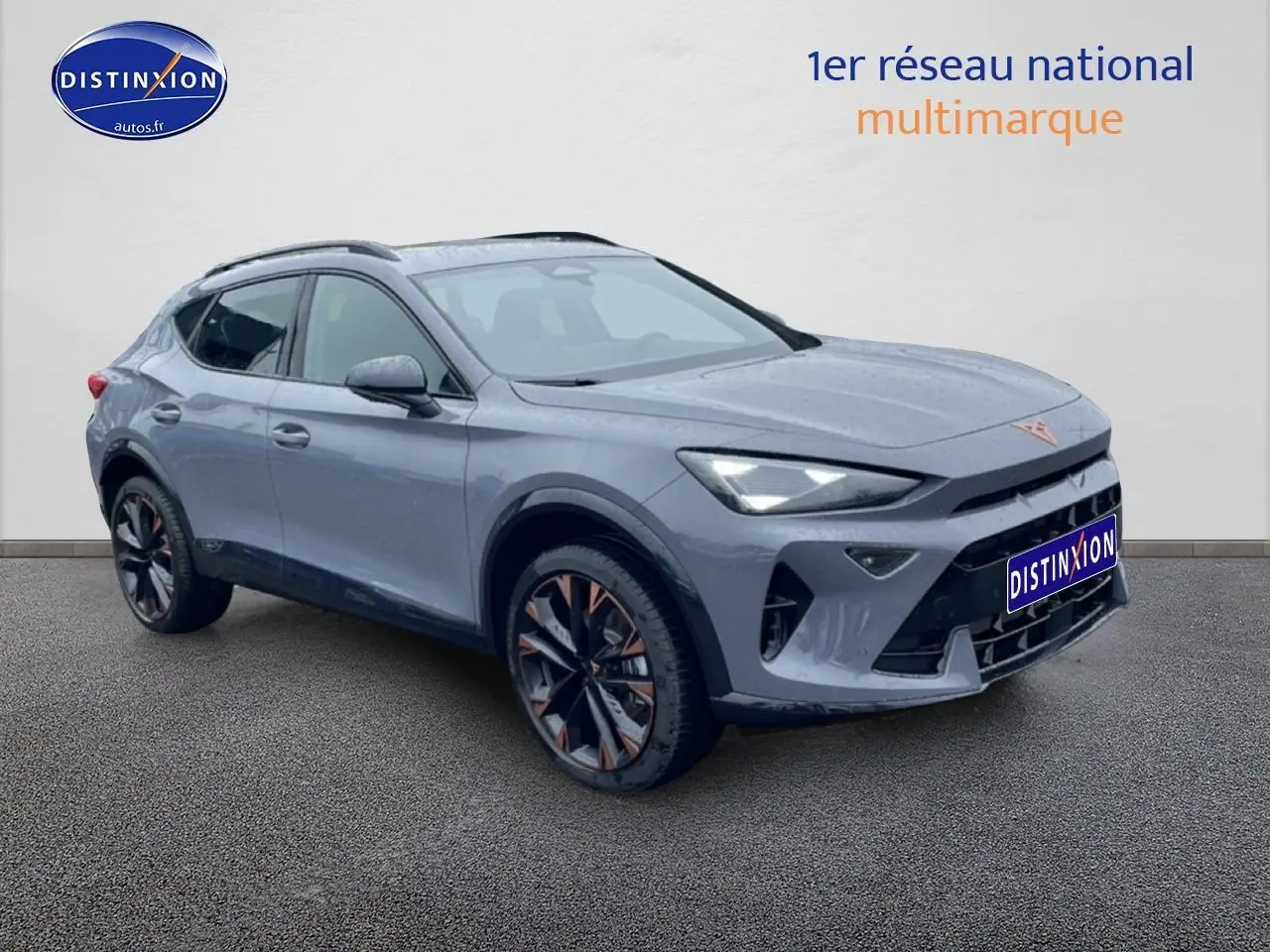 Vue 3/4 avant d'un CUPRA Formentor gris graphene avec jantes noires et détails cuivrés, sur fond neutre.