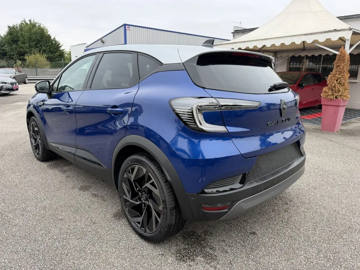 Vue 3/4 arrière droite du Renault Captur Esprit Alpine bleu avec toit blanc et jantes noires distinctives.