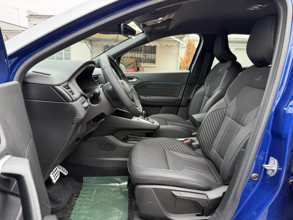 Vue intérieure côté gauche de la Renault Captur Esprit Alpine bleu, sièges avant noirs avec logo Alpine brodé.