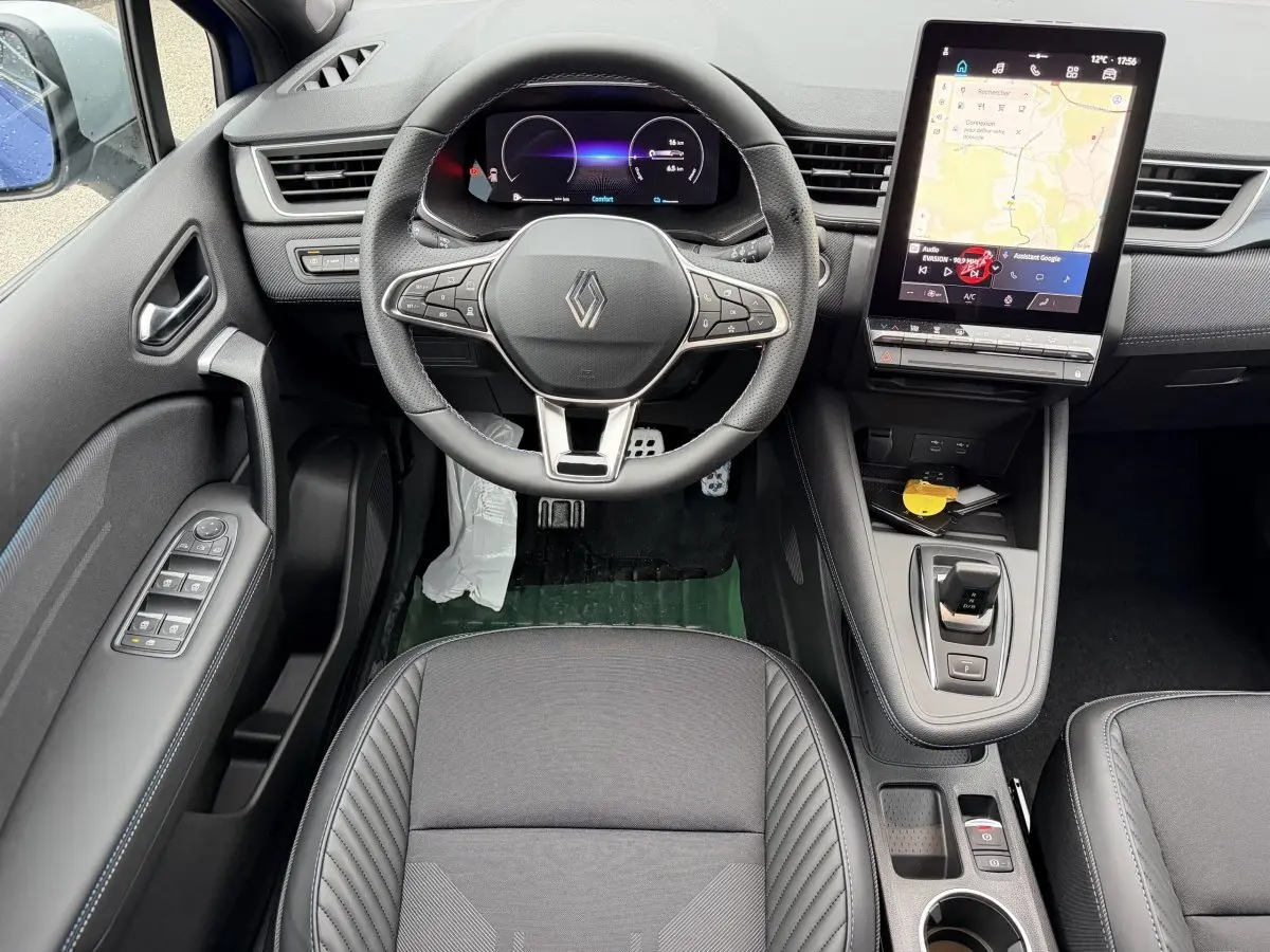 Vue intérieure avant du Renault Captur esprit Alpine 2026, volant multifonctions, écran tactile vertical et sellerie noire.