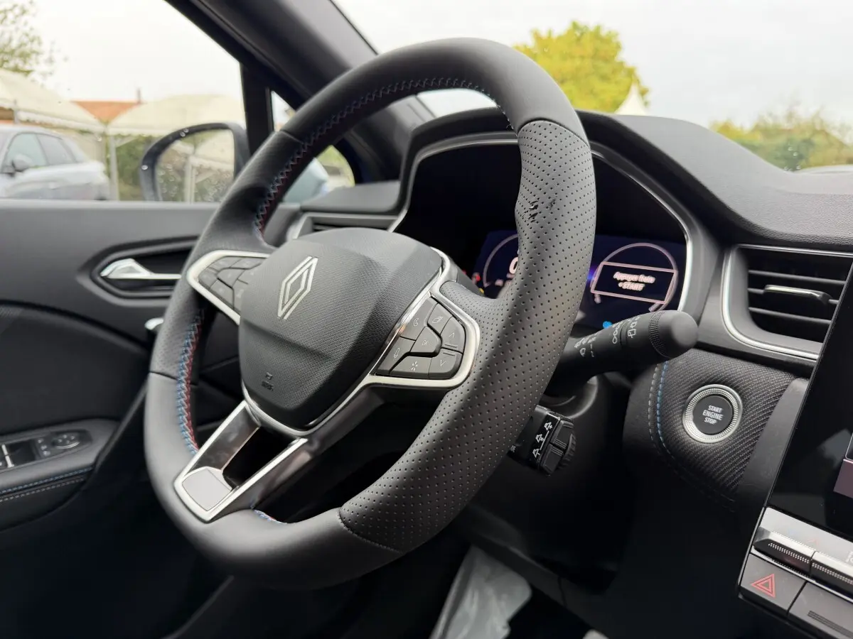 Vue intérieure rapprochée du volant cuir perforé et du tableau de bord du Renault Captur esprit Alpine 2026.