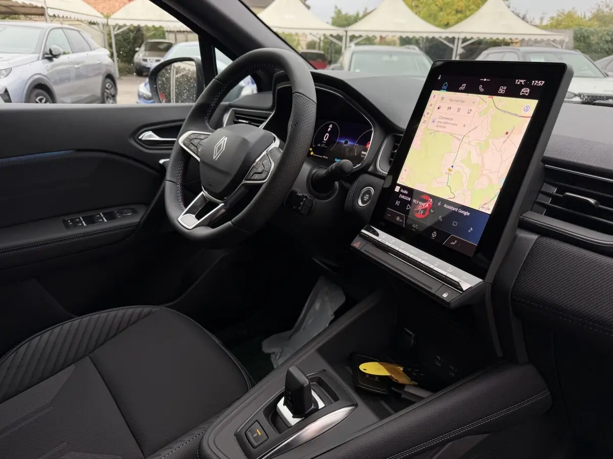 Vue intérieure côté conducteur du Renault Captur Esprit Alpine hybride 2026, avec écran tactile central affichant la navigation.